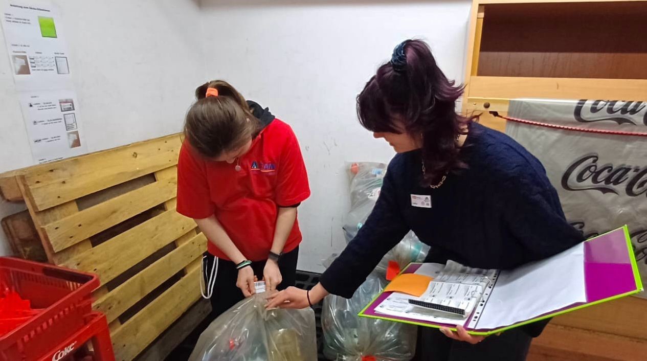 Zwei Frauen verpacken Pfandflaschen in Plastiksäcke.