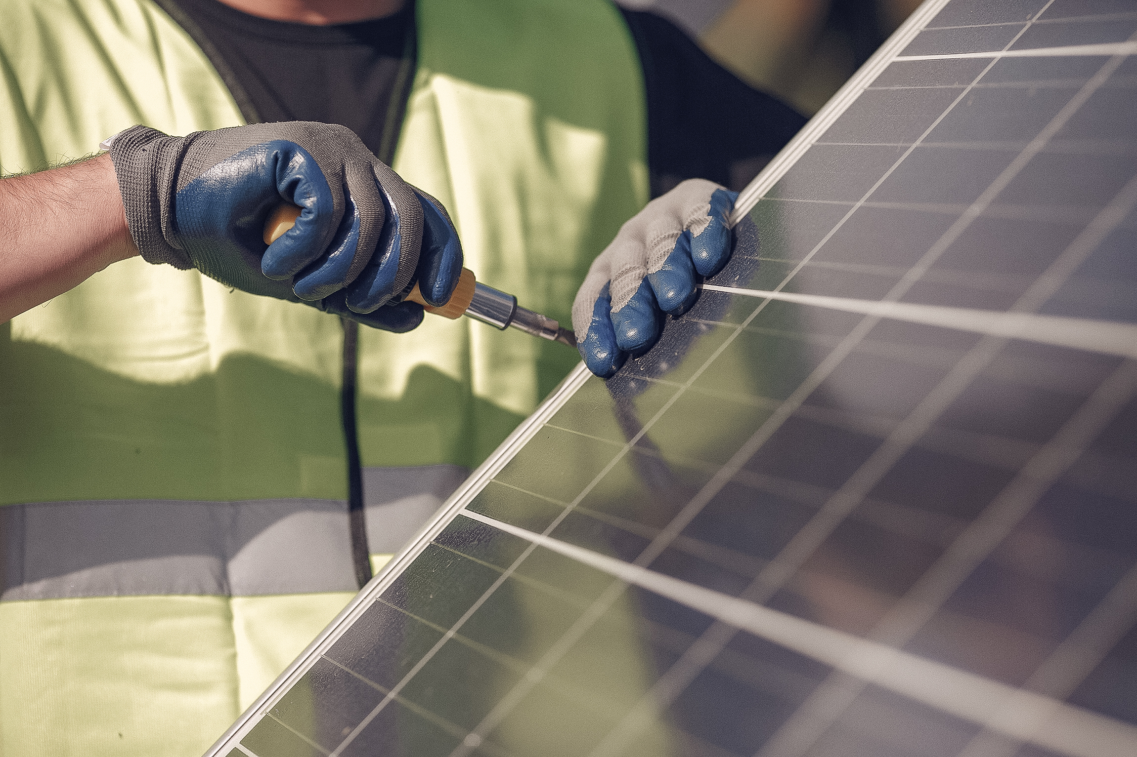 Eine Person schraubt an einem Solar Panel