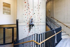 Person klettert an einer Kletterwand in einem Innenbreich