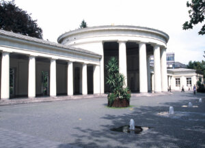 Der Elisenbrunnen in Aachen. Davor kleine Wasserfontänen.