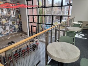 Blick von oben auf die neugestaltete Lobby der Jugendherberg Köln-Deutz mit heller Glasfront