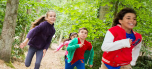 Vier Kinder machen ein Wettrennen druch den Wald.