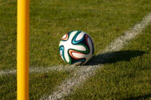 Ein Fußball liegt am Spielfeldrand vor einer Eckfahne.