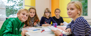 Vier Kinder sitzen gemeinsam an einem Tisch und lernen